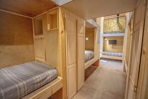 A compact, wooden interior with bunk beds and built-in wardrobes. - Social Stays On State Street (Santa Barbara)