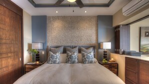 A bedroom with a large bed, two bedside tables, a nightstand, a wall-mounted lamp, a mirror, and a wooden wardrobe. - Signature by Pinnacle (Puerto Vallarta)