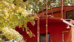 A vintage train caboose with a ladder, a door, and a sign that reads 'EASY RIDER.' - Easy Rider Railroad Caboose Cabin (Upper Lake)