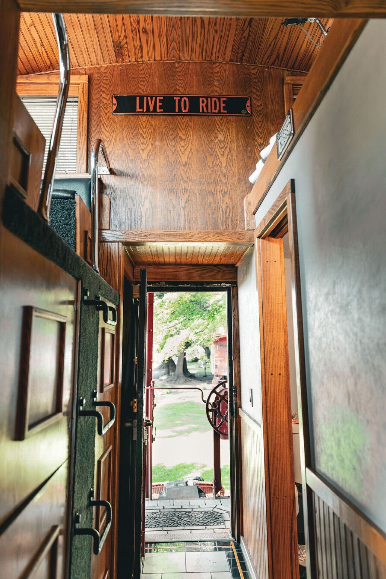 A wooden interior hallway with a sign that reads 'LIVE TO RIDE.'