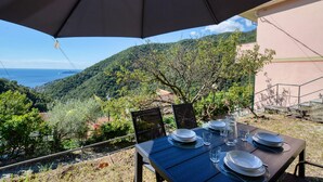 An outdoor dining area with a table set for four, overlooking a scenic hillside and the sea. - 2 bedroom gorgeous apartment in Semorile (Semorile)