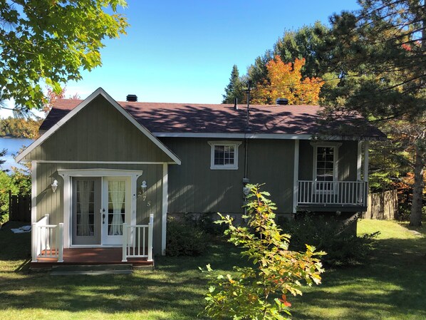 A two-story house with a front porch, a small deck, and a garage.