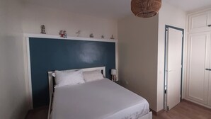 A bedroom with a bed, a nightstand, a wardrobe, and a wall-mounted shelf with decorative items. - Fishermen's house with 4 x 8 m mooring line available (Empuriabrava)