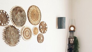 A blue sofa with striped pillows, a woven basket, and wall decor. - Fishermen's house with 4 x 8 m mooring line available (Empuriabrava)