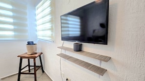 Relax in this stylish living space with a flat-screen TV, wooden shelves, and a cozy reading nook.