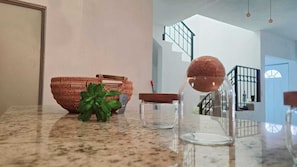Enjoy cooking in this stylish kitchen with a granite countertop, featuring a woven basket, a potted plant, and a charming storage jar.