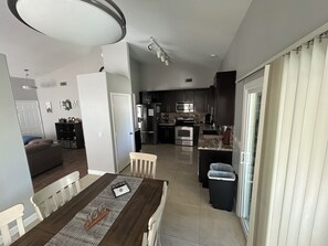 A modern kitchen with a central island, dark cabinetry, and stainless steel appliances.