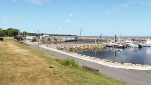 A marina with boats docked, a parking area, and a grassy area with a pathway. - 3 bedroom cozy home in Tomelilla (Tomelilla)