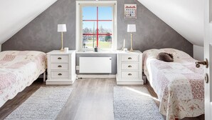 A bedroom with two beds, a desk, and a window with a red cross design. - 3 bedroom cozy home in Tomelilla (Tomelilla)