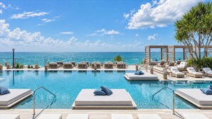 A poolside area with lounge chairs and a view of the ocean. - 1Hotel South Beach  OceanView, Pool, Gym, (Miami Beach)