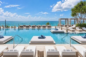 A poolside area with lounge chairs and a view of the ocean. - 1Hotel South Beach  OceanView, Pool, Gym, (Miami Beach)