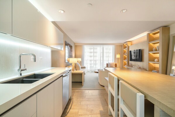 A modern hotel kitchen with a central island, a built-in sink, and a flat-screen TV mounted on the wall. - 1Hotel South Beach  OceanView, Pool, Gym, (Miami Beach)