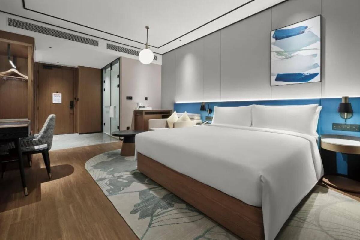 Une chambre d’hôtel moderne avec un grand lit, un bureau et une chaise.