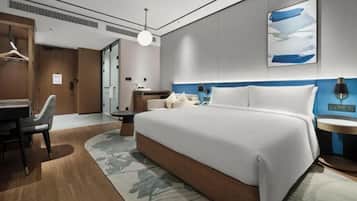 Una habitación de hotel moderna con una cama grande, un escritorio y una silla.