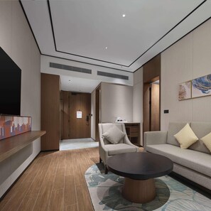 A modern living room with a sofa, armchair, coffee table, and artwork on the walls. - Hilton Garden Inn Beijing Yizhuang (Beijing)