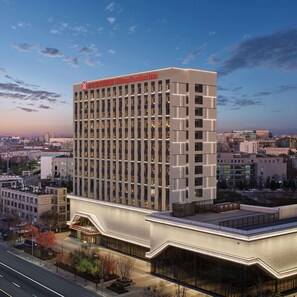 A modern hotel building with a prominent sign, multiple floors, and a large entrance area. - Hilton Garden Inn Beijing Yizhuang (Beijing)