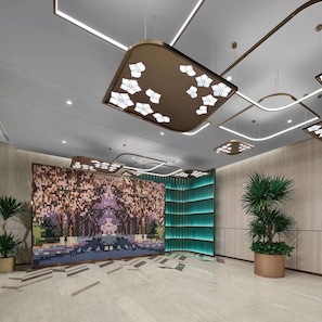 Een moderne lobby met een patroonwand, inbouwverlichting en een gebogen wand in teal blauw.
