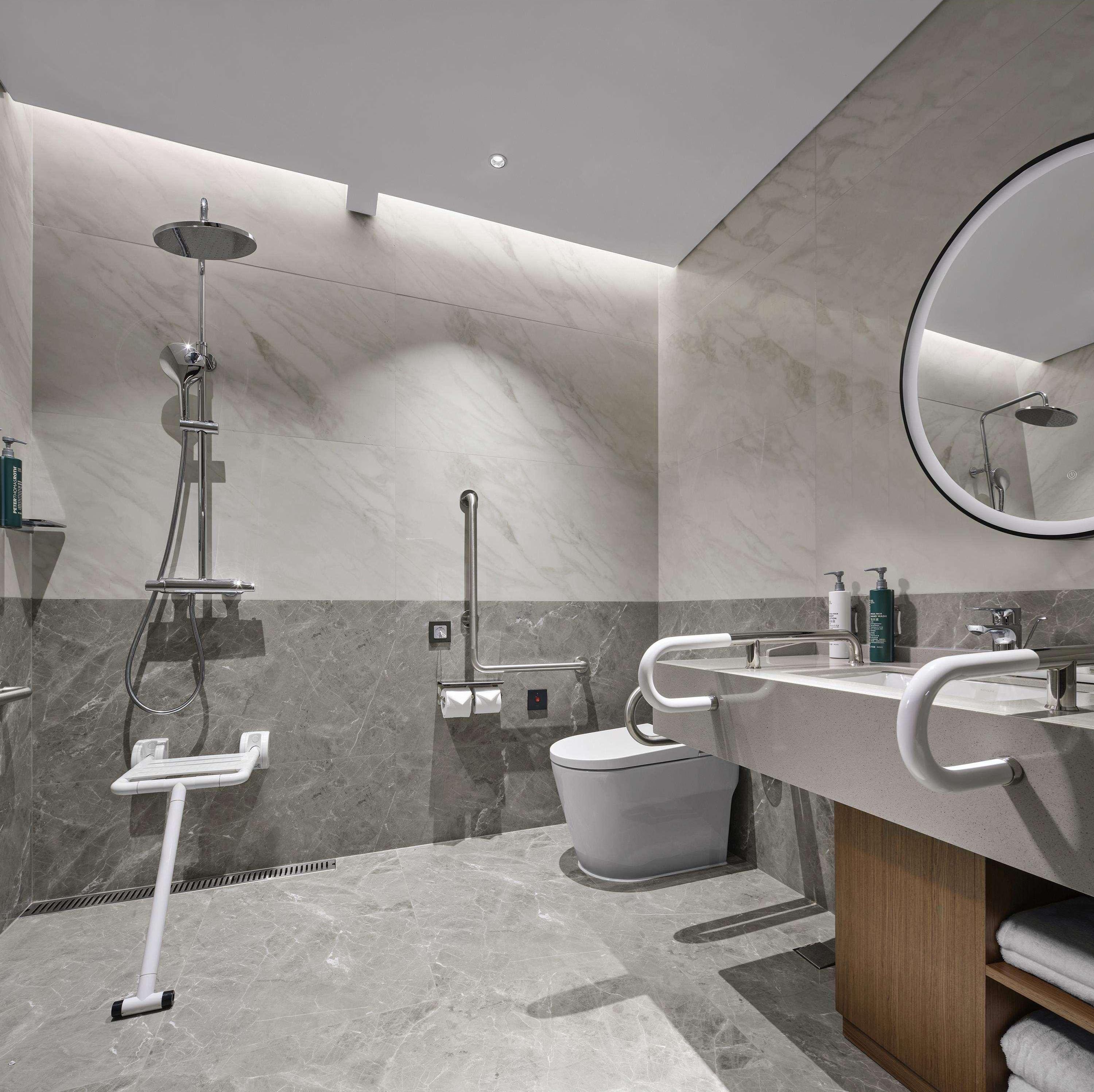 A modern bathroom with a shower, toilet, and sink.