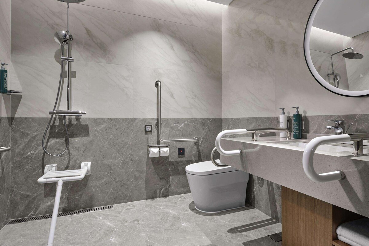 Une salle de bain moderne équipée d’une douche, de toilettes et d’un lavabo.