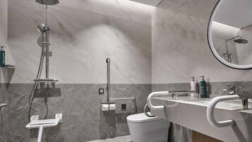 A modern bathroom with a shower, toilet, and sink.