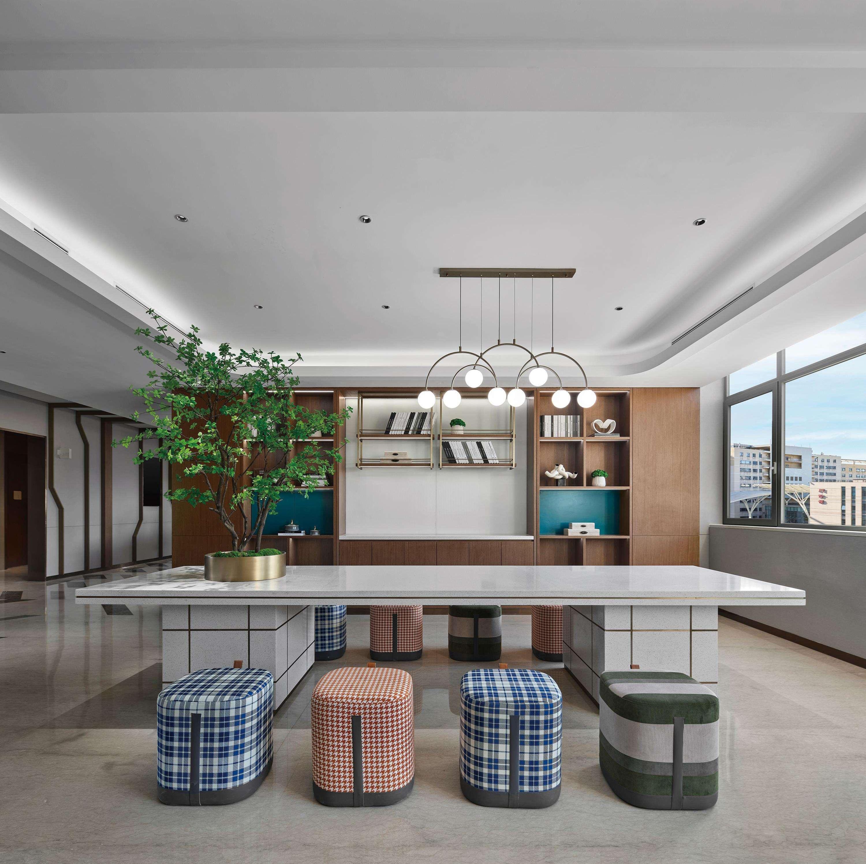 Una cocina moderna con una isla central, iluminación colgante y un amplio ventanal con vistas a la ciudad.
