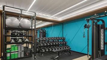 A gym with weightlifting equipment, kettlebells, and dumbbells.