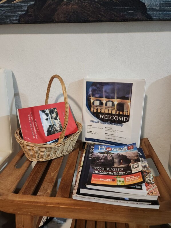 A wooden bench with a wicker basket containing a red booklet titled "Travel Puerto Rico" and a "Welcome" sign for Dream Tropical Getaway.
