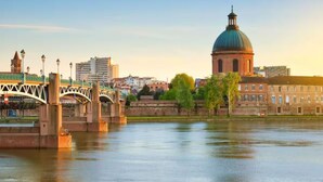 Un río con un puente y un edificio con cúpula.