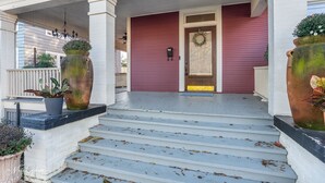 A front porch with steps leading to a door, a mailbox, and two large planters. - Spacious 4-bedroom house in enjoyable Shreveport with WiFi, AC (Shreveport)