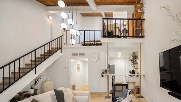 A spacious living area with a staircase, a dining area, and a kitchen.