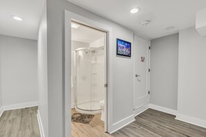 Un baño moderno con cabina de ducha de vidrio, inodoro y lavamanos.