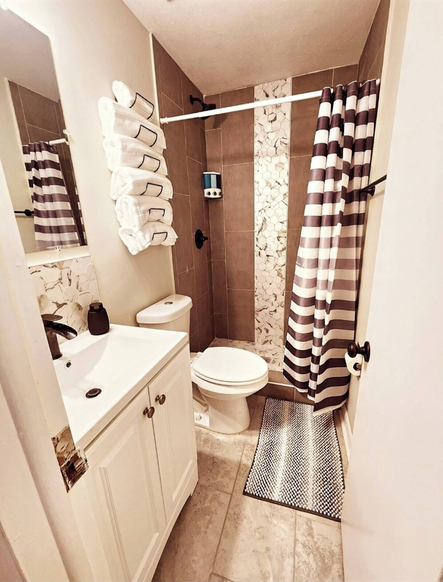 A compact bathroom with a toilet, sink, and shower area.