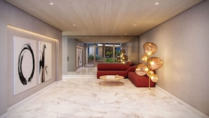 A modern interior with a marble floor, a red sofa, a gold-framed coffee table, and abstract wall art. - Studio exclusivo Brooklin 230m do metrô (S ão Paulo)