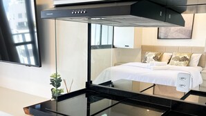 A modern kitchen with a black countertop, green cabinets, and a built-in stove. - Studio exclusivo Brooklin 230m do metrô (São Paulo)
