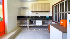 A compact kitchen with a black countertop, a sink, and wooden cabinets.