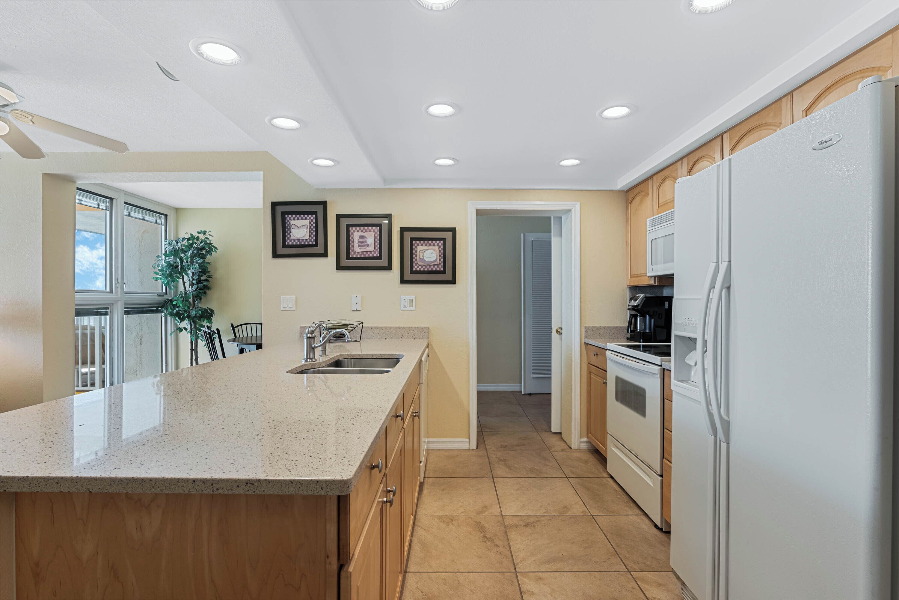 A modern kitchen with a large island, built-in appliances, and a view to the dining area.