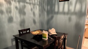Una mesa de comedor con sillas, una botella de producto de limpieza y un tapón sobre la mesa.