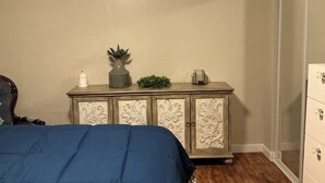 Un dormitorio con cama, cómoda y espejo.