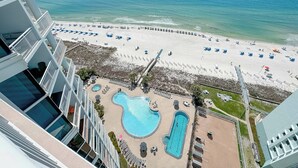 A hotel with a pool area, beach access, and a view of the ocean.