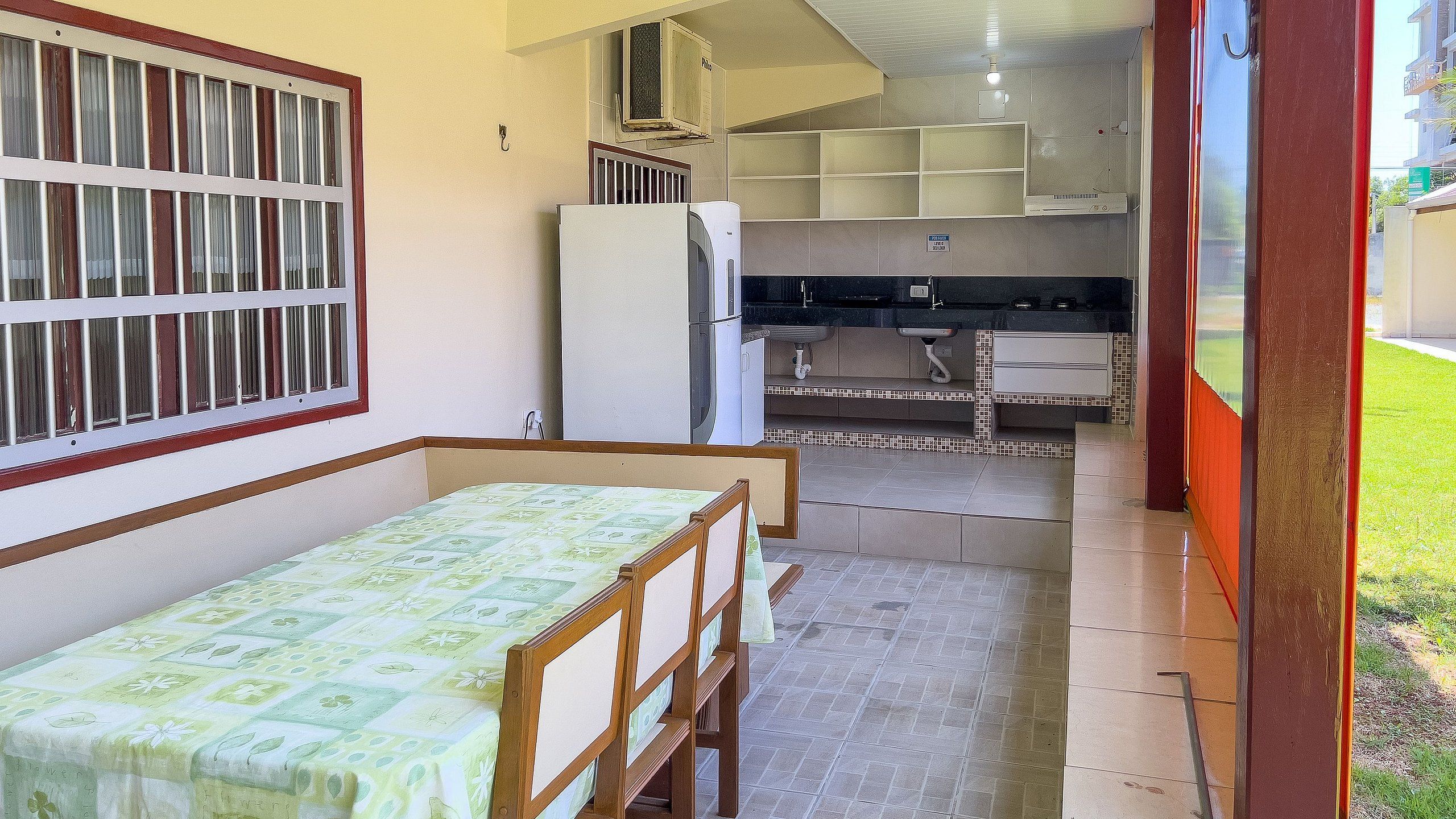 Een kleine, compacte kamer met een bed, een kitchenette en een raam met tralies.