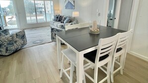 A modern kitchen with a dark countertop, white cabinetry, and a ceiling fan. - Cozy 5BR-2.5BA Cottage on Canal, Private Heated Pool, Private Boat Dock (Ocean Isle Beach)