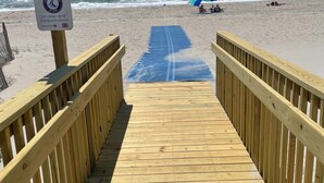 A wooden boardwalk leading to a beach with a sign thanking visitors for beach clean-up. - Cozy 5BR-2.5BA Cottage on Canal, Private Heated Pool, Private Boat Dock (Ocean Isle Beach)