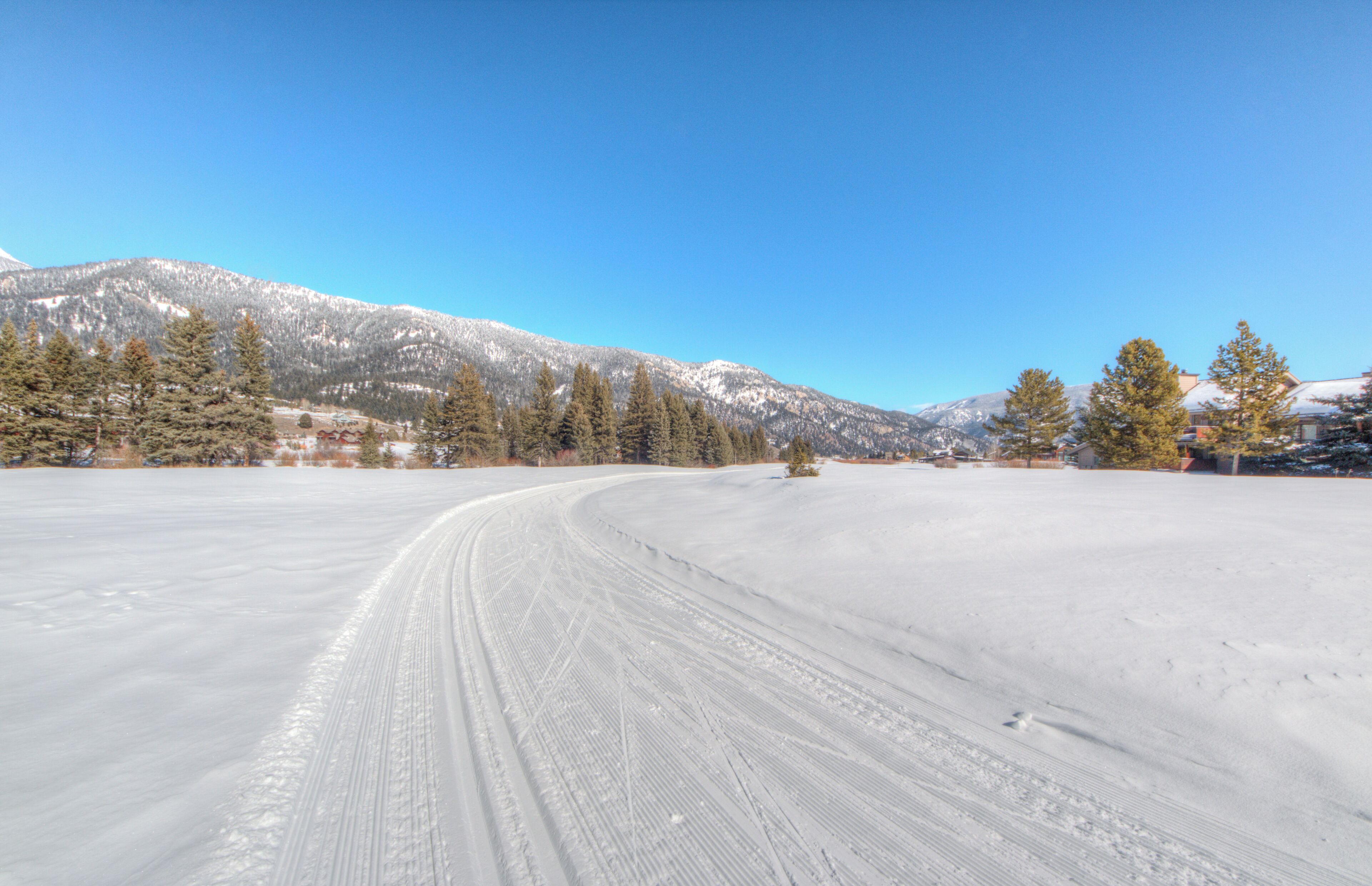A snow-covered landscape with a clear sky and a winding path.