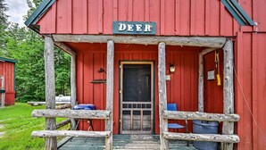 A red wooden building with a sign reading "DEER" above the entrance. - Charming 3-bedroom cottage in peaceful Solon with WiFi (Solon)