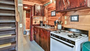 A rustic kitchen with wooden cabinets, a white stove, and a sink. - Charming 3-bedroom cottage in peaceful Solon with WiFi (Solon)