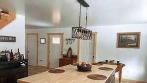 Un'ampia cucina con un'isola grande, pensili in legno e un lampadario a sospensione.