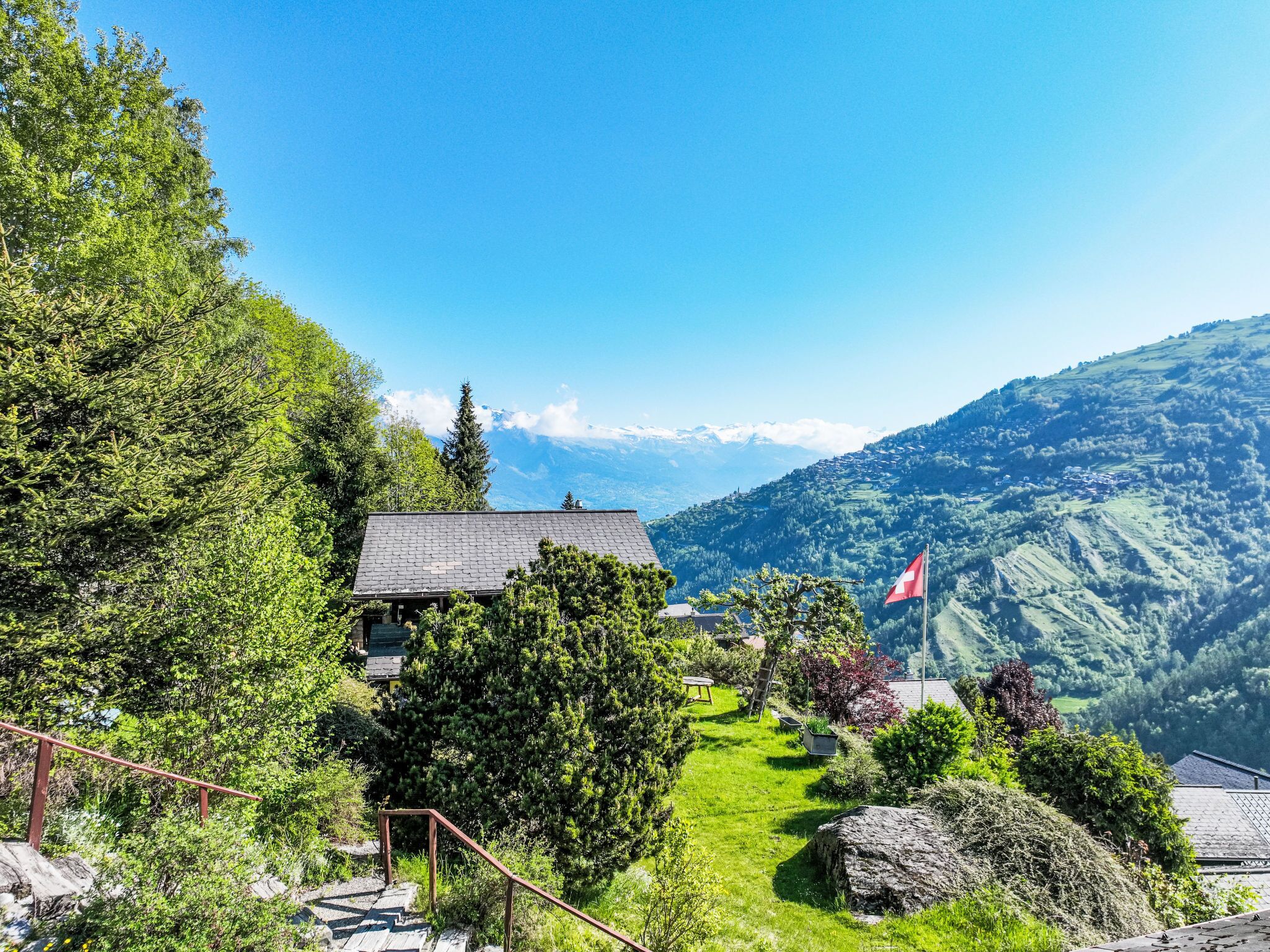 A mountain lodge with a clear view of the surrounding landscape and a flag.