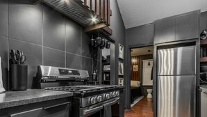 A modern kitchen with a stainless steel stove, oven, and refrigerator. - The Iverson - Urban Core OKC (Oklahoma City)