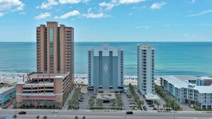 Ein Küstenhotel mit mehreren Gebäuden, einem Parkplatz und einem Strand im Hintergrund.