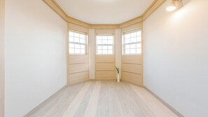 Une pièce d’angle avec un plancher en bois, des murs blancs et une fenêtre donnant sur un beau paysage.